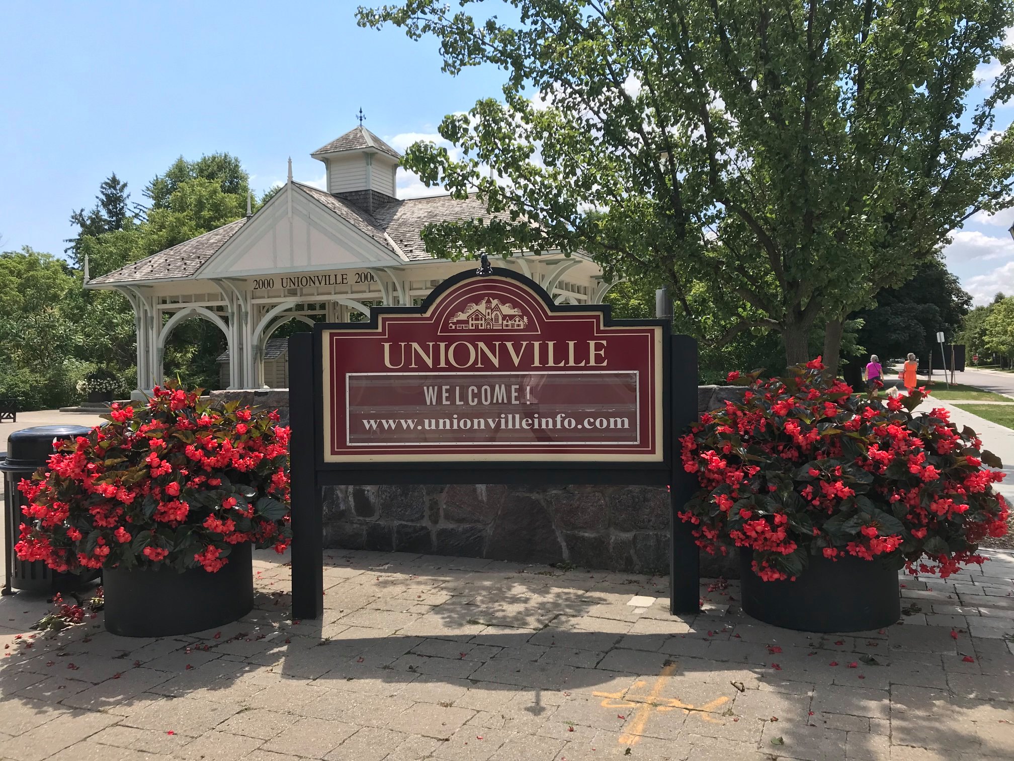 Millennium Bandstand with bright red flowers and Welcome to Unionville Sign